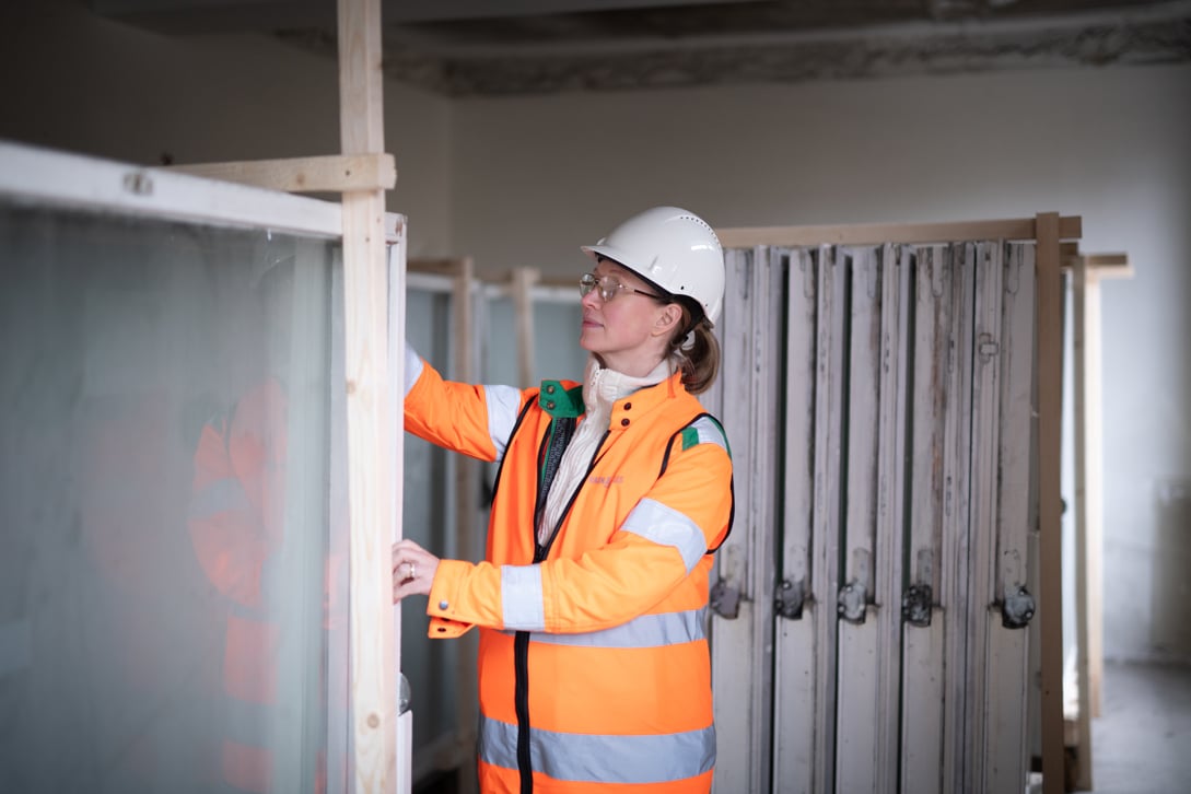 En kvinna från Ragn-Sells inspekterar fönster som ska återvinnas